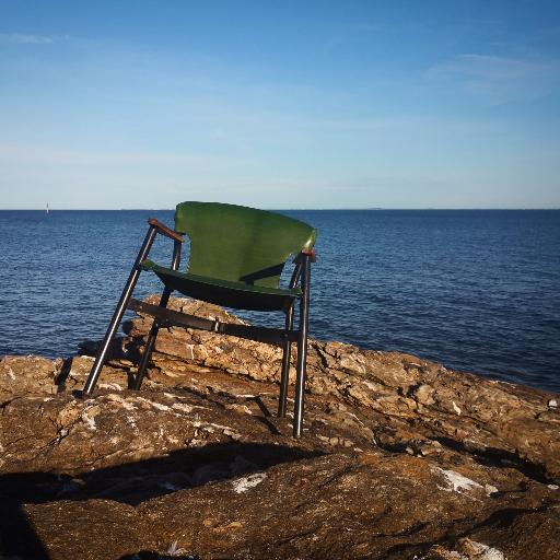 fauteuil pliant galathee en cuir vert sur les rochers en bord de mer